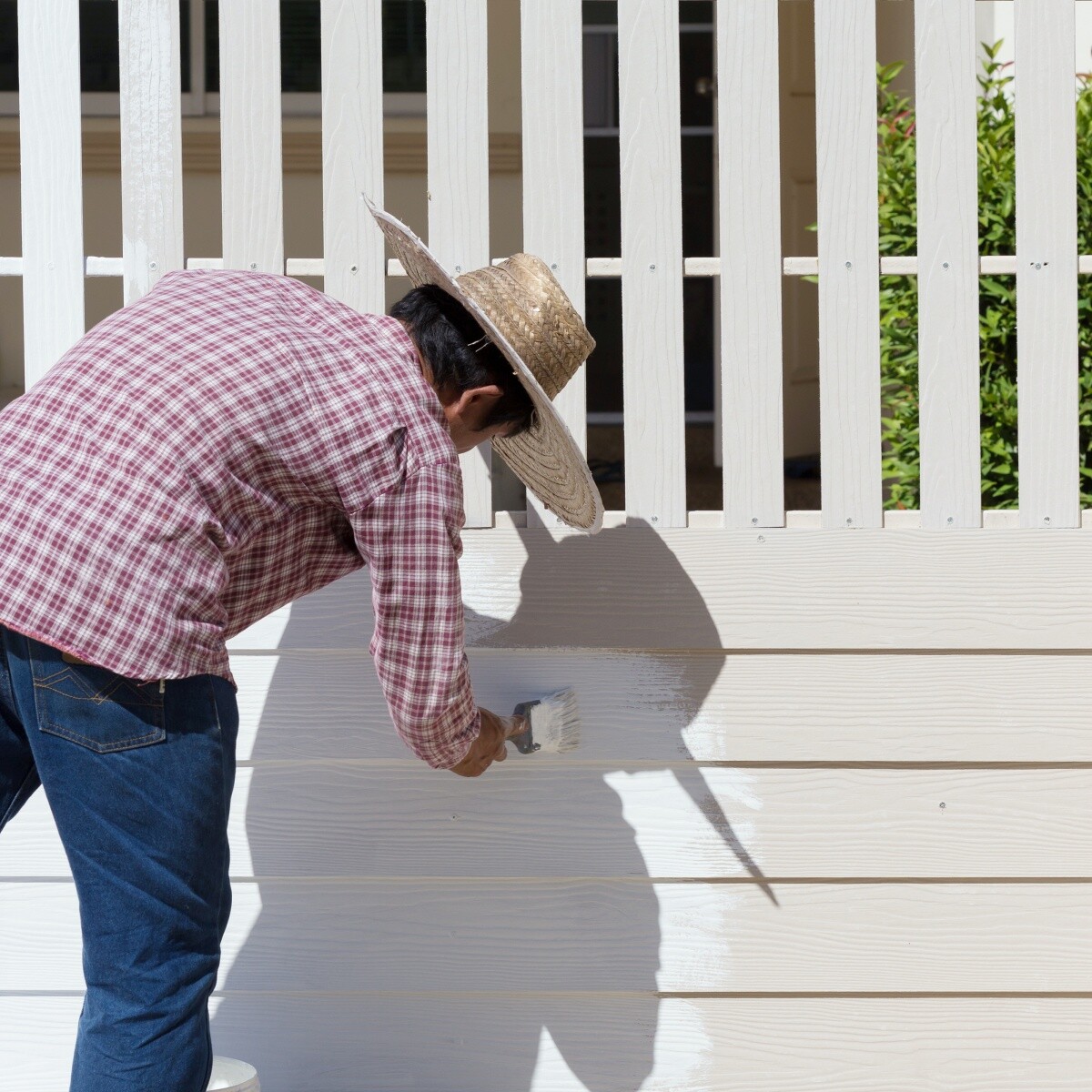 man painting white fence