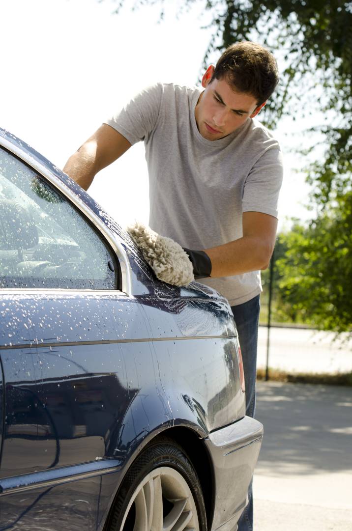 a man scrubbing a car with a sponge