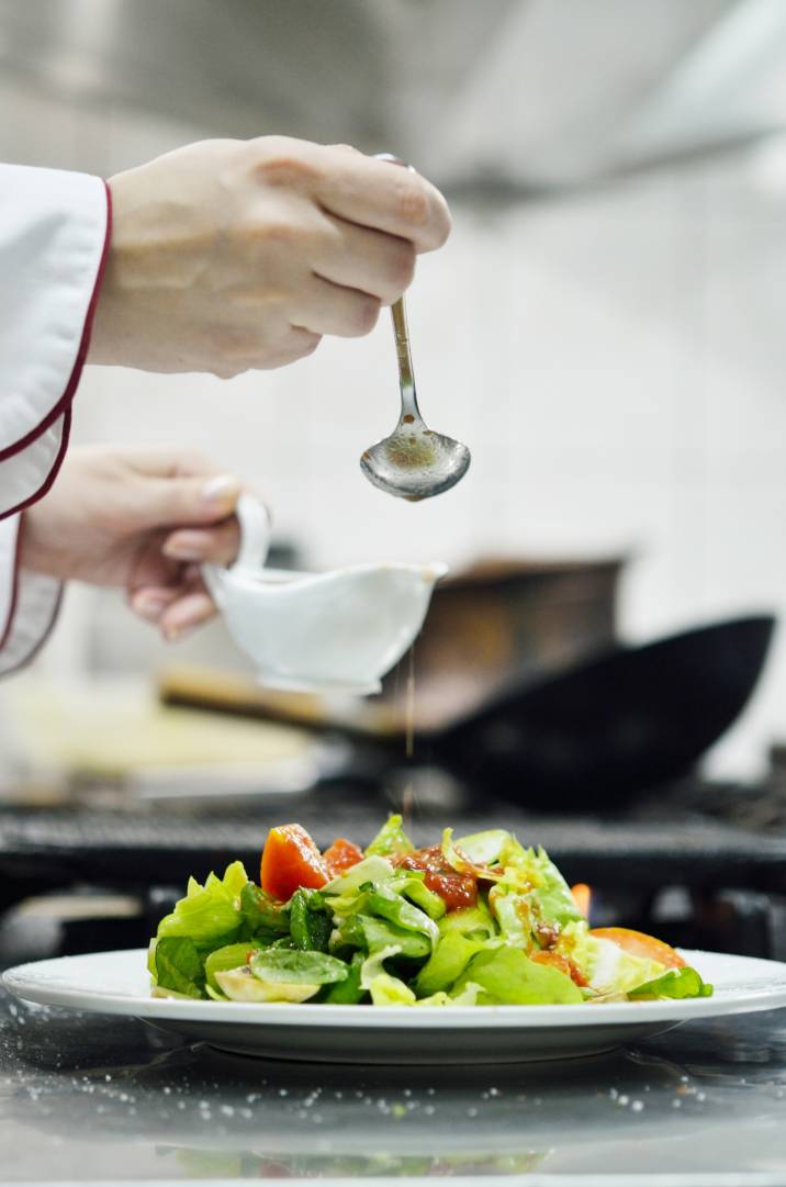 a personal chef garnishing a salad