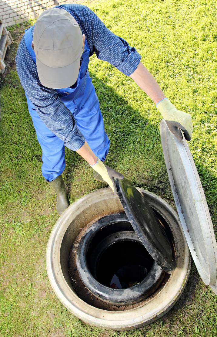 a handyman opening an underground water tank 
