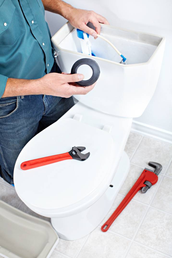 a plumber repairing a toilet