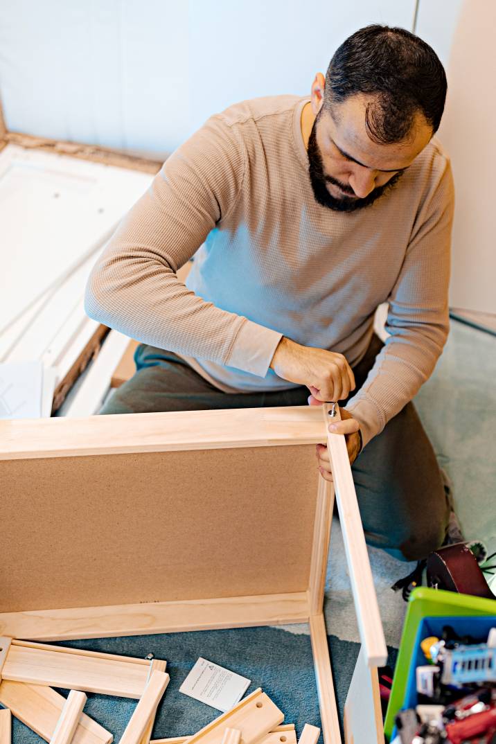 a handyman assembling a small wooden table