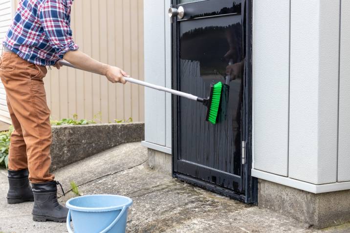 Man scrubbing a door exterior
