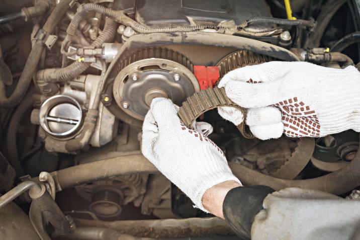 a mechanic replacing a rusty timing belt