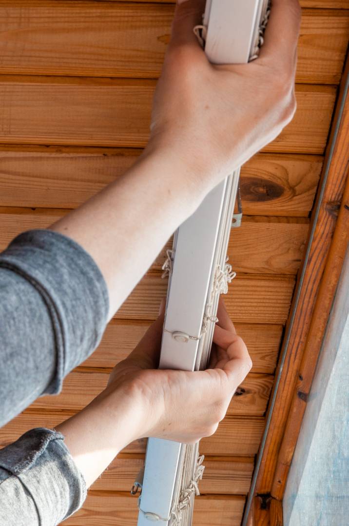 a handyman installing white blinds