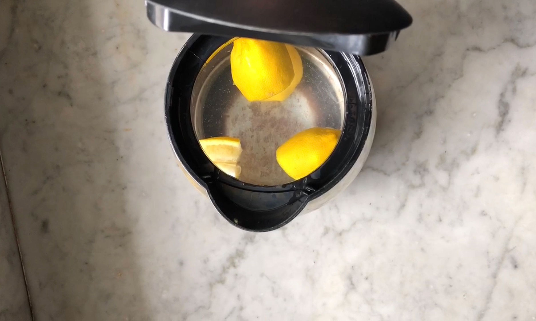 lemons in clear kettle on marble benchtop